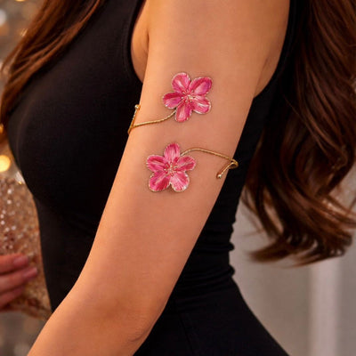 Rosé Bloom arm band worn on bare upper arm against a black outfit, close-up of twin pink flower design
