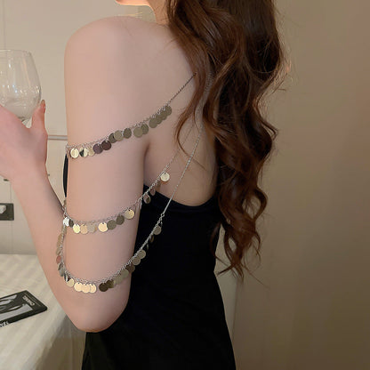 Disc charm shoulder body chain worn over a bikini