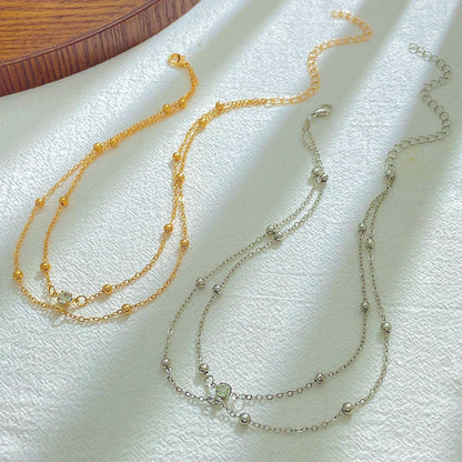 Dual-layer crystal choker worn at the base of the throat