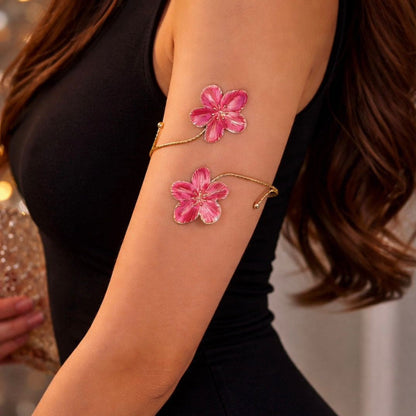 Rosé Bloom arm band worn on bare upper arm against a black outfit, close-up of twin pink flower design